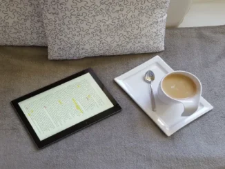 A cozy scene with a tablet displaying text next to a cup of coffee on a soft surface, suggesting a relaxed reading experience about health and wellness products.