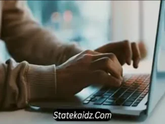 Close-up of a person's hands typing on a laptop keyboard, with "Statekaidz.com" watermarked at the bottom of the image.