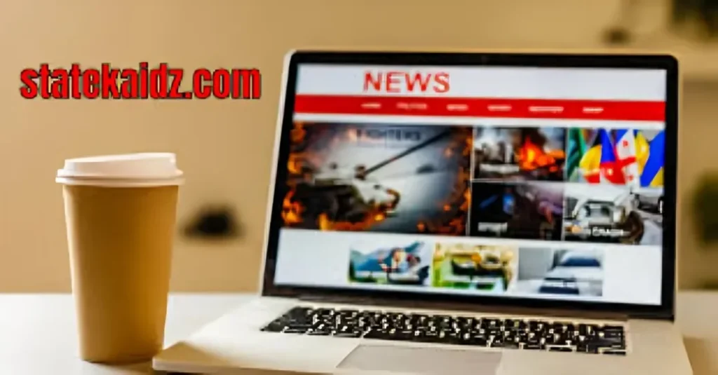 A laptop displaying a "NEWS" webpage with various article previews, next to a disposable coffee cup on a light-colored surface. The logo "statekaidz.com" is digitally overlaid in red text at the top left.