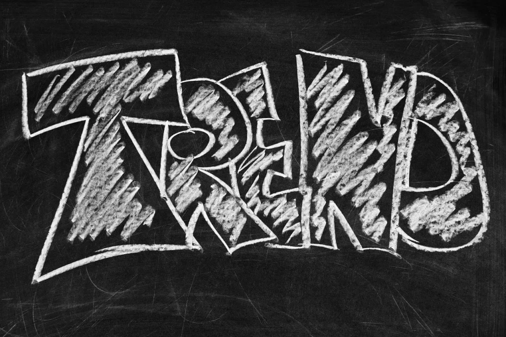 The word "TREND" aggressively written in white chalk-style lettering on a dark chalkboard, visually representing a viral phenomenon gaining momentum.

