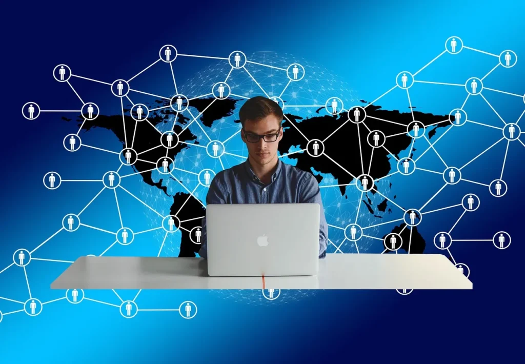 A man working on a MacBook laptop, superimposed over a digital network graphic with a world map and connected person icons, symbolizing the viral spread of a trend across digital platforms in the USA.